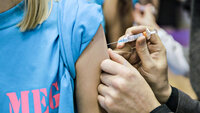 Bildet viser en arm det blir satt vaksine i.