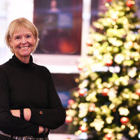 Bildet viser Anne Hafstad, redaktør i Sykepleien, smilende foran et tent juletre