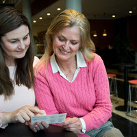 To kvinnelige sykepleiere leser en lommefolder.