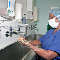 Bildet viser en operasjonssykepleier som vasker hendene før operasjon