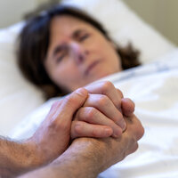 Bilde av sykepleier som holder pasient i hendene