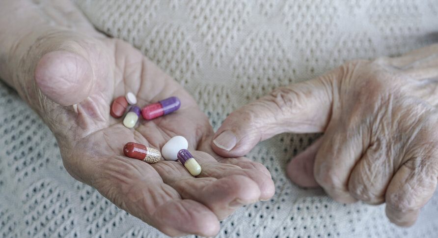 bildet viser gamle hender med piller