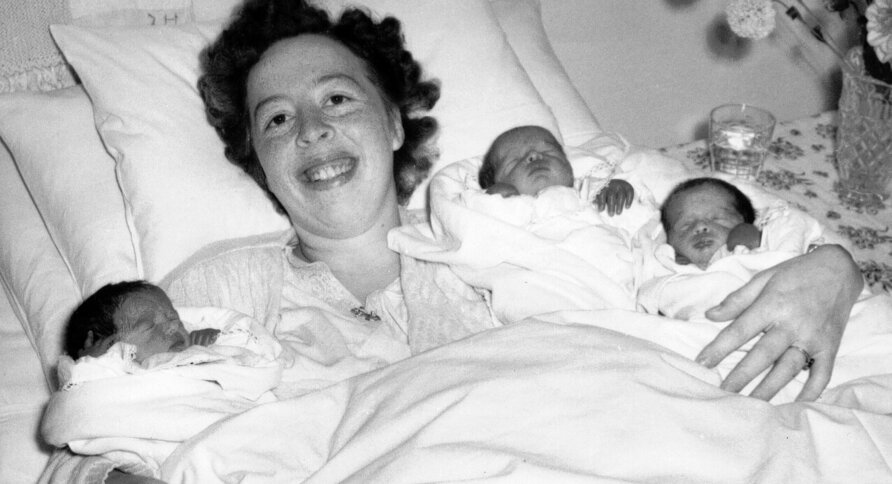 Bildet viser en nybakt mor med trillinger etter hjemmefødsel
